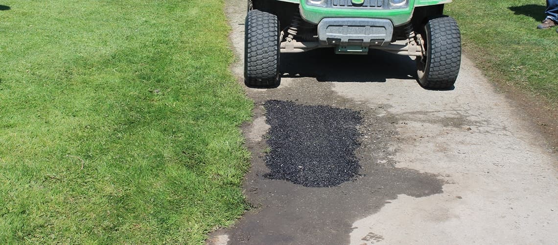 Golf cart driving over completed EZ Street repair