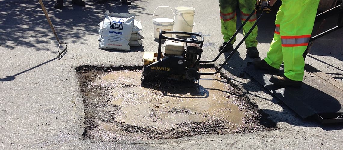 Compacting EZ Street with plate compactor